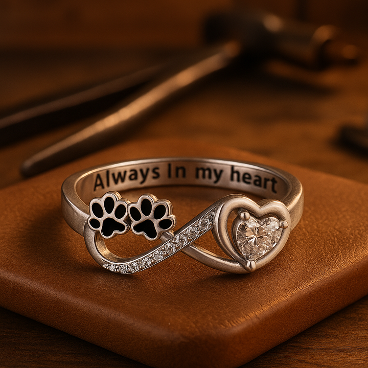 Ring mit pfotenförmigen Zirkonia-Steinen, Herz- und Unendlichkeitssymbol.