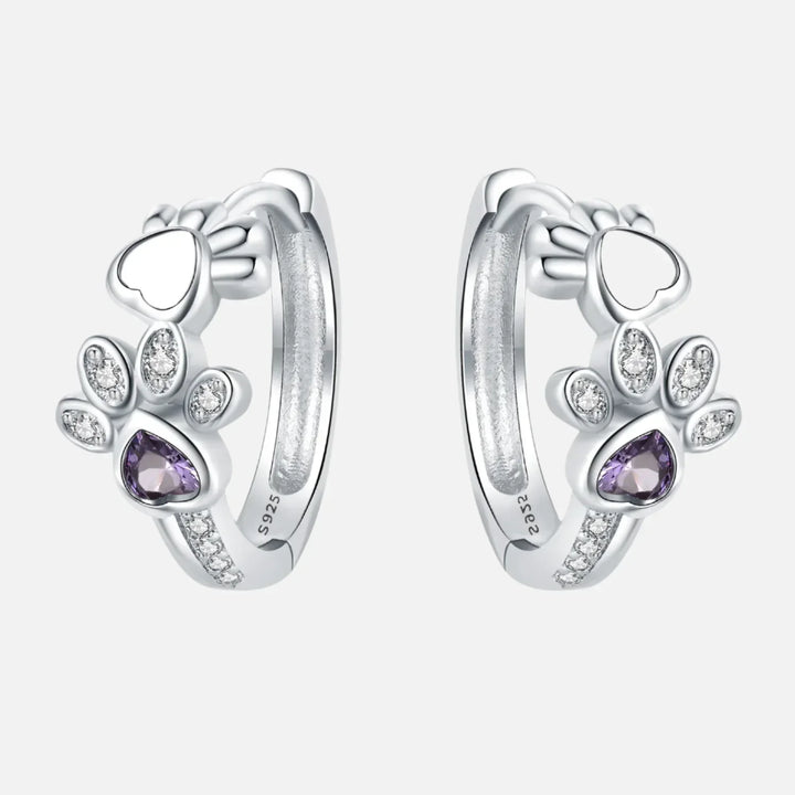 Ohrringe mit Pfotenabdruck in Silber, mit Zirkonia und einem herzförmigen Edelstein.